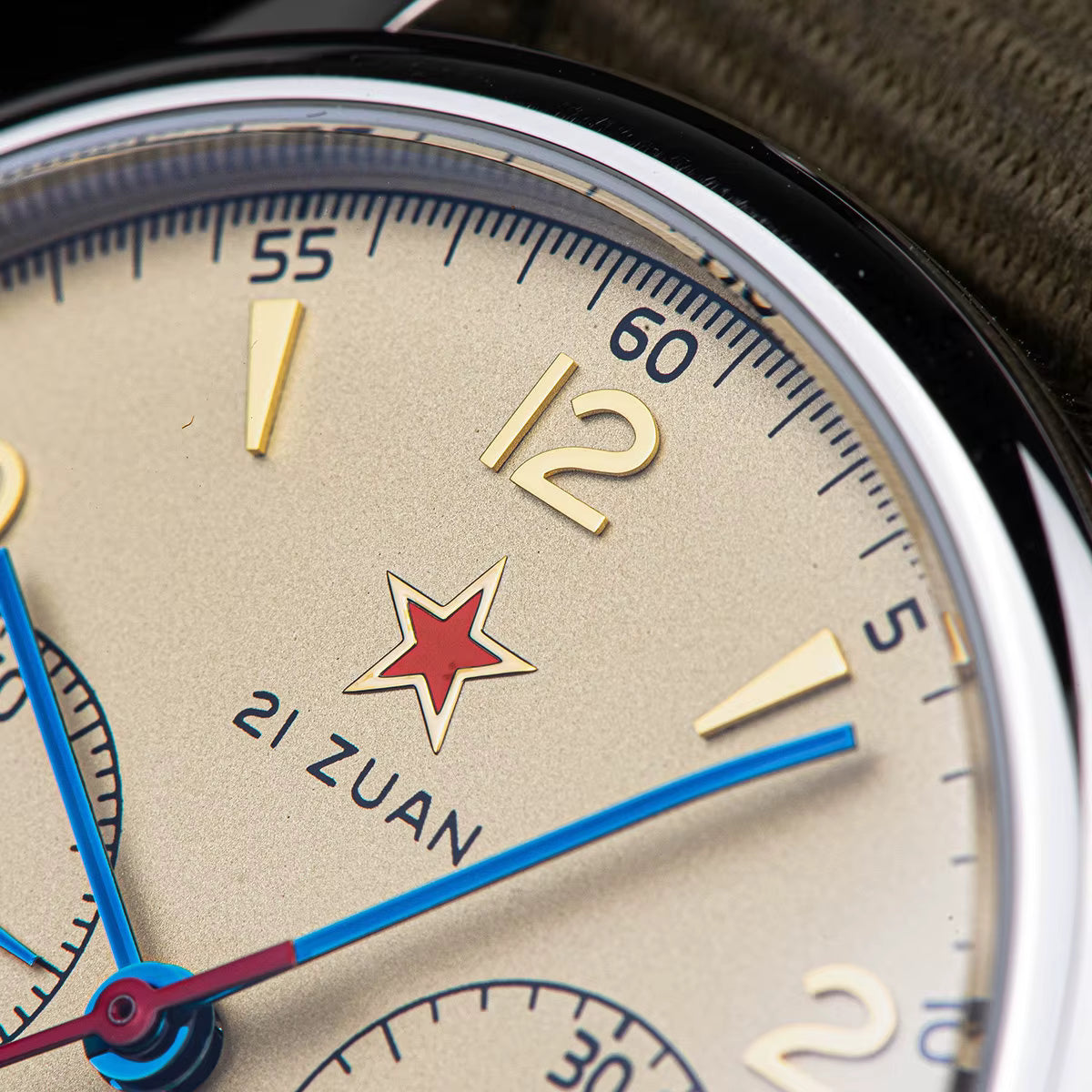 Macro close up of Seagull 1963 cream dial featuring red star logo, blue hands, and vintage pilot chronograph details